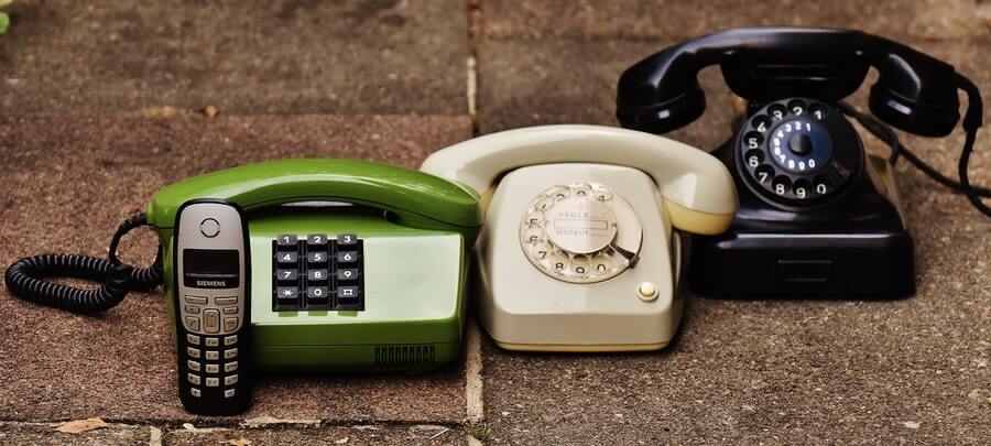 For phones side by side on the ground, from rotary to dial to old Nokia-style brick cell phone.