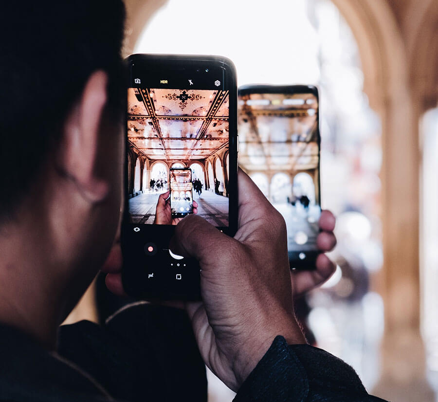 Picture of man taking picture of a phone taking a picture of some Architecture - super meta/recursive.