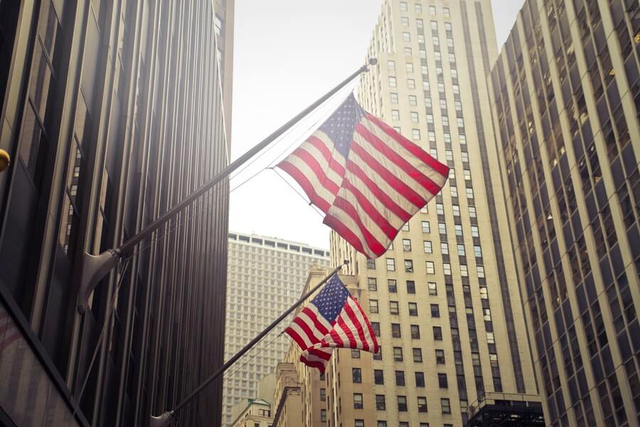 Two American (USA) Flags being flown in an urban metropolis, probably New York City.