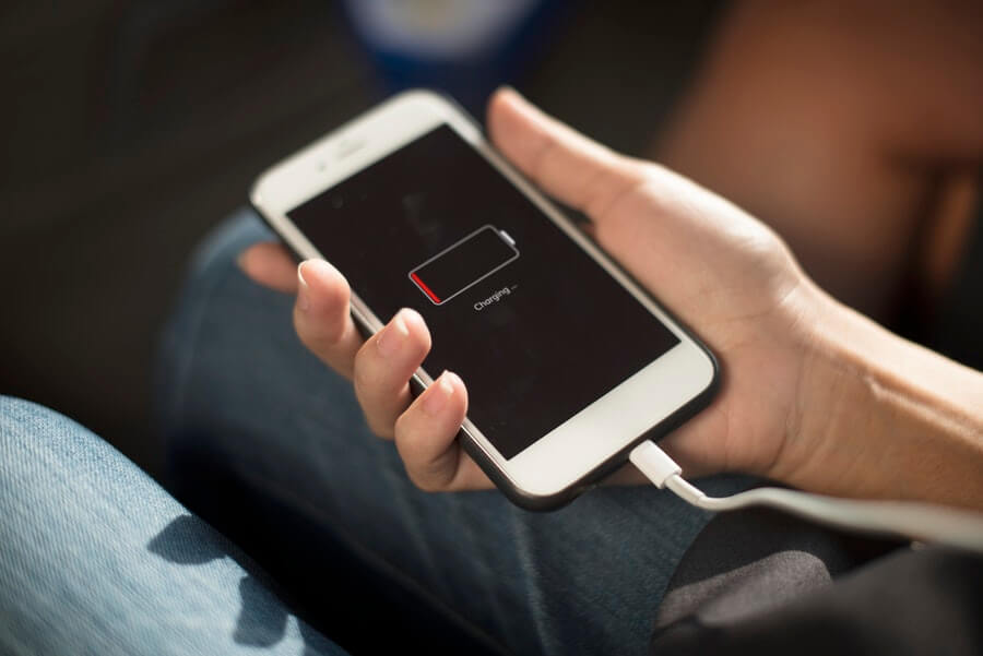 White iPhone 6 with dead battery being charged by usb lightning cable.