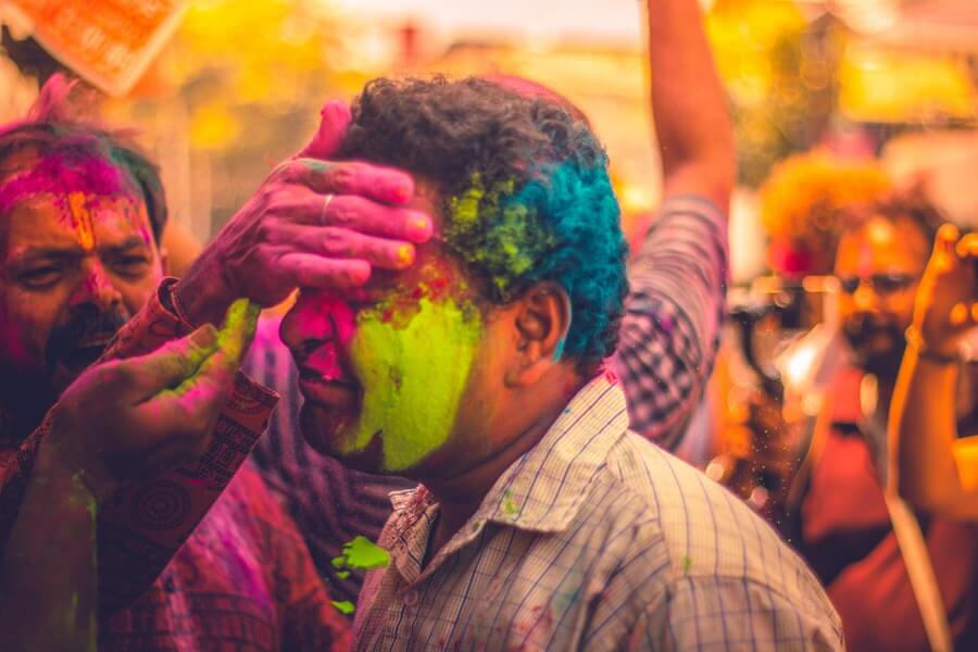 Person being covered in colors during the Holi festival.