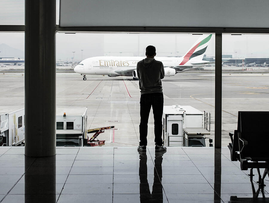 Guy waiting at the airport, possibly because of Emirates.