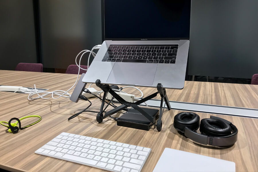 The Traveling Office: A Full Setup Including MacBook Pro, Roost Laptop Stand, Apple Magic Trackpad, Apple Magic Keyboard, USB Hub, a Couple External Hard Drives, Two Sets of Headphones, and more.