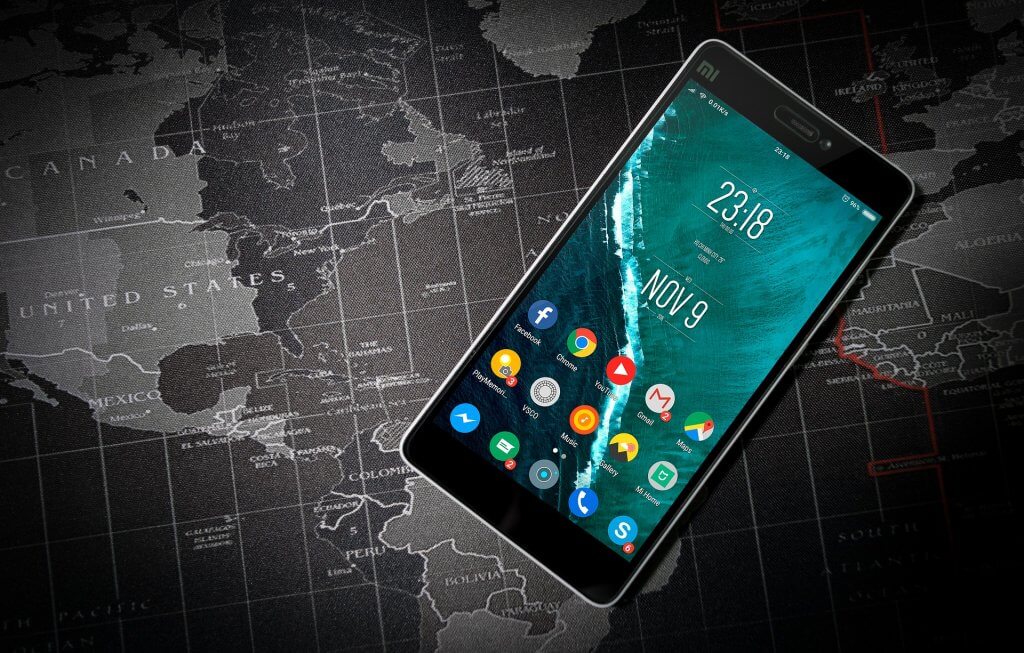 Android tablet with apps, on top of black and white world map.