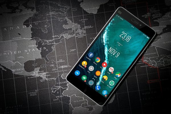 Android tablet with apps, on top of black and white world map.