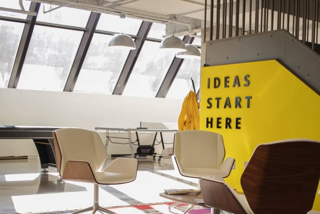 Modern coworking space with seating area, various tables (ping pong, pool).