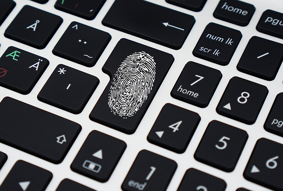 Keyboard with fingerprint on enter/return key, symbolizing digital/online security.