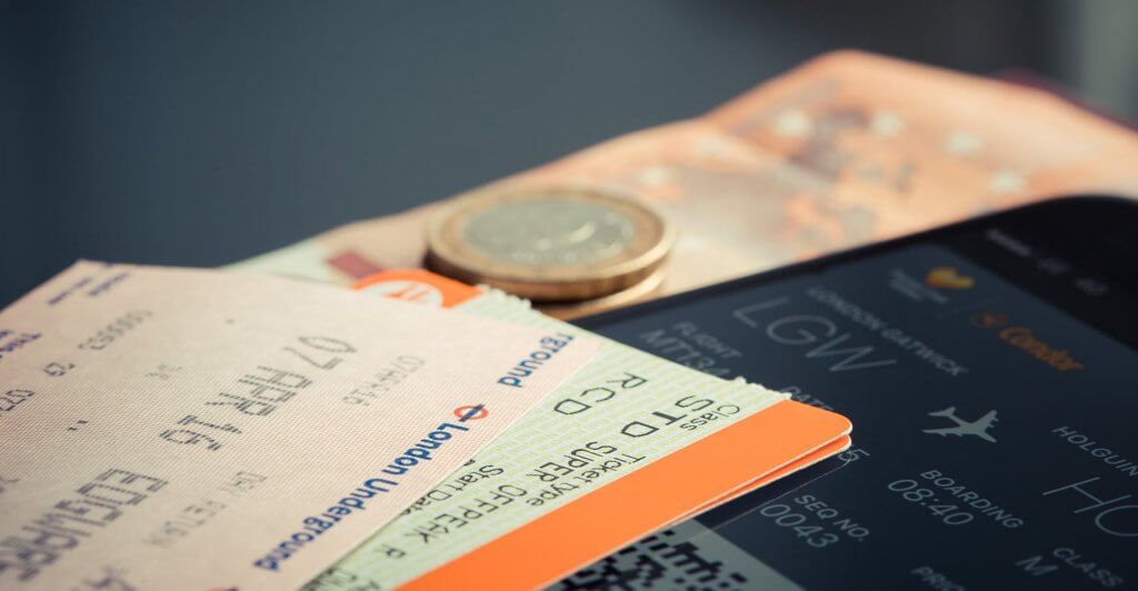 Physical and digital plane tickets with cash.