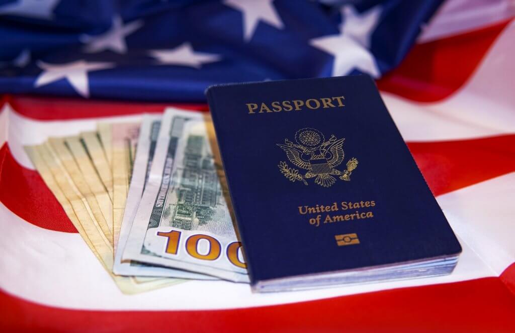 United States passport with cash on the American flag